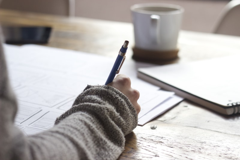 Persona escribiendo y planificando en un cuaderno, organizando ideas para un proyecto de branding