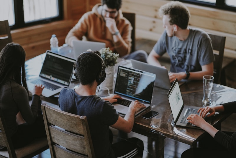 Equipo de profesionales colaborando alrededor de una mesa de trabajo en una sesión creativa